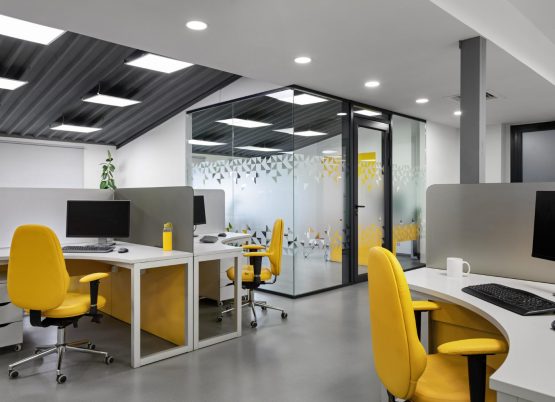 bright-yellow-it-office-with-glass-wall-with-workplaces-employees-developers